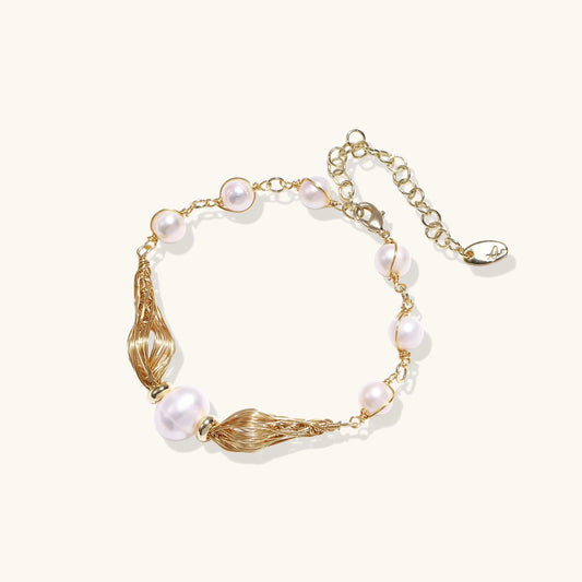 Adjustable gold bracelet with freshwater pearls and textured filigree beads on white background, showing clasp detail.