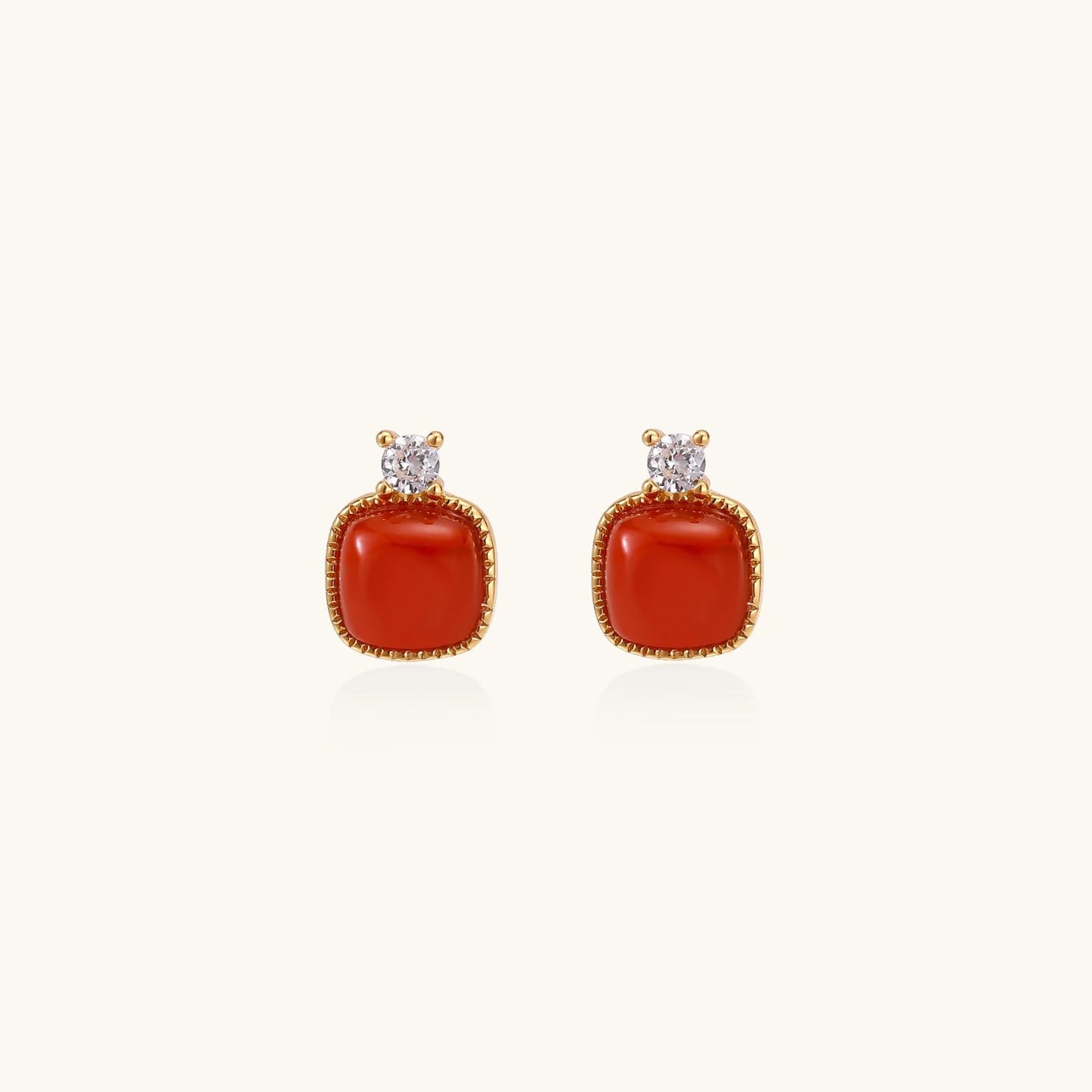18K gold vermeil stud earrings with cushion-cut red agate stones and sparkling crystal accents on beige background