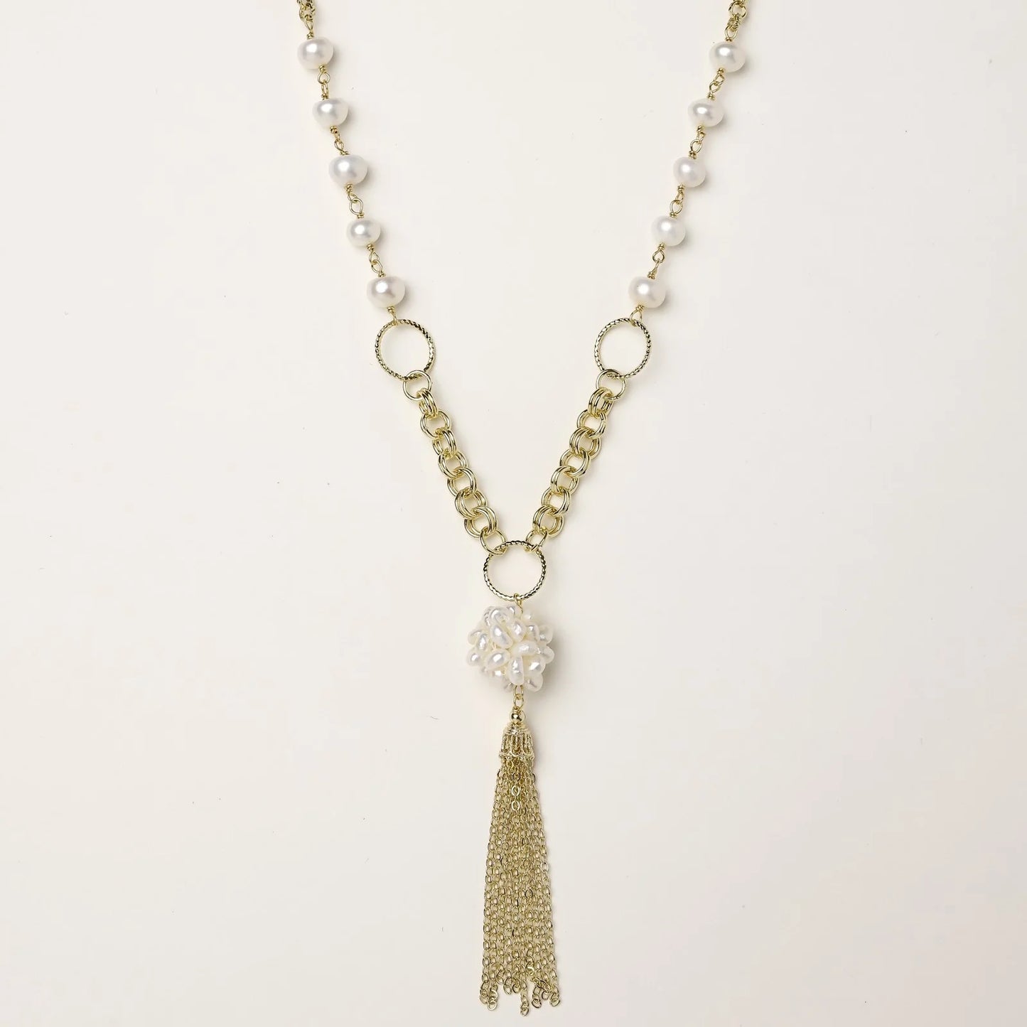 Long gold-plated necklace with freshwater pearls, chunky chain links, and flowing tassel pendant