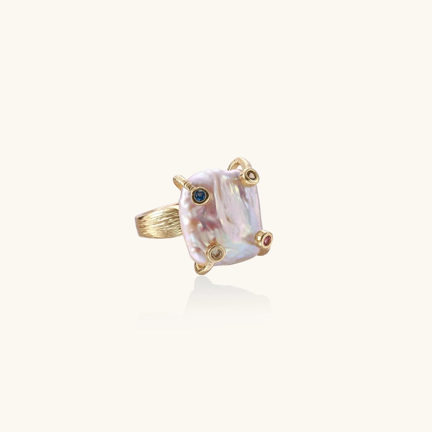 Gold ring with large iridescent baroque pearl and four colored gemstones on textured band