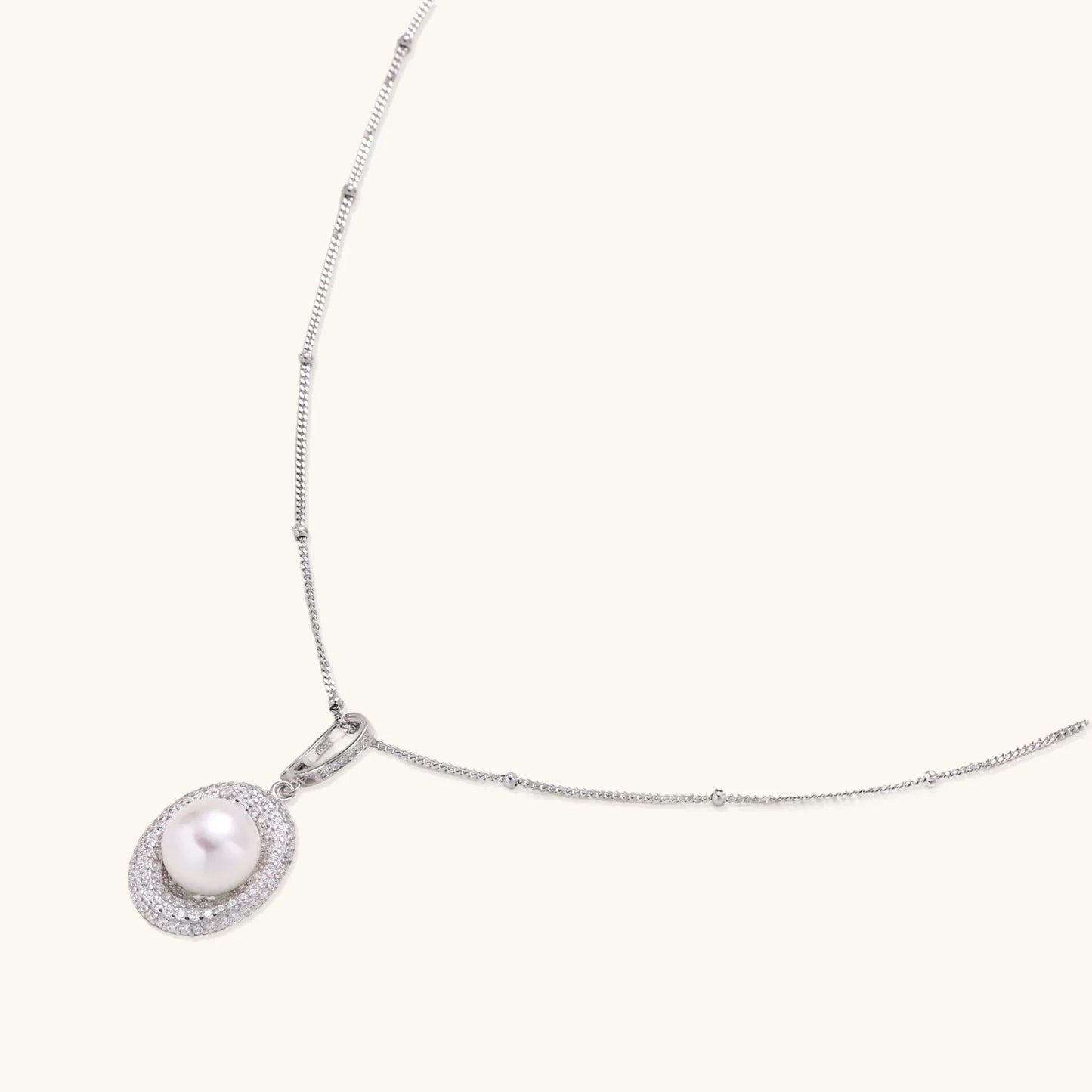 Oval sterling silver pendant with crystal halo surrounding a white freshwater pearl on delicate chain