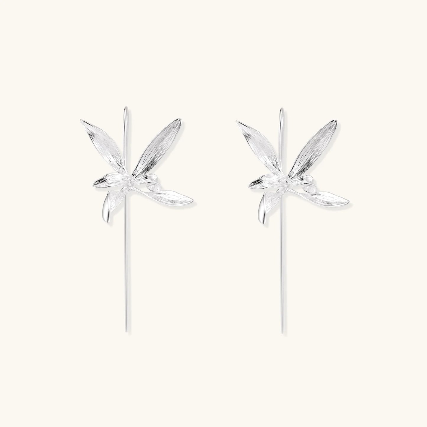 Delicate sterling silver dragonfly earrings with textured wings and curved threader hooks on white background