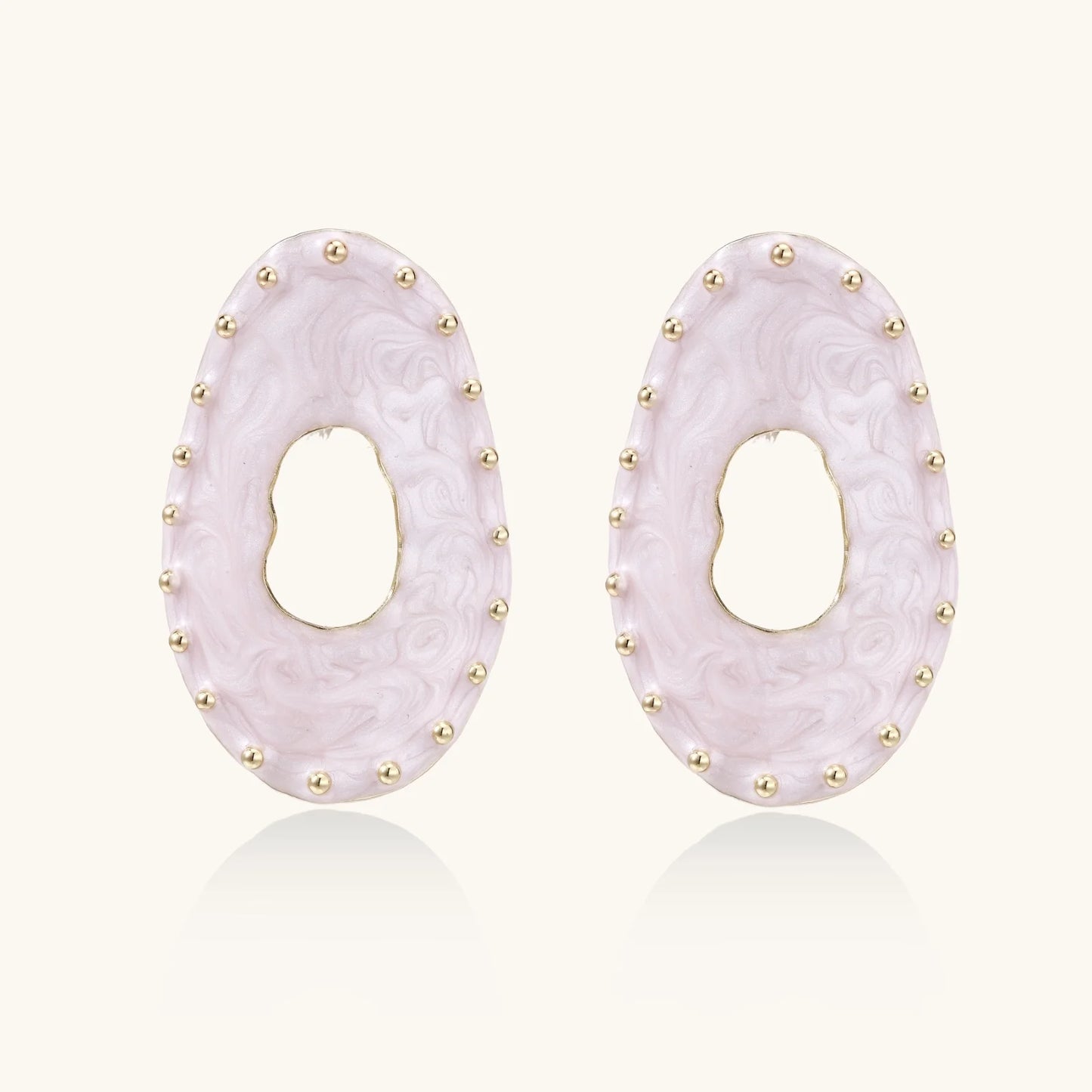 Oval lavender enamel earrings with marbled finish and gold-plated beaded border on cream background.