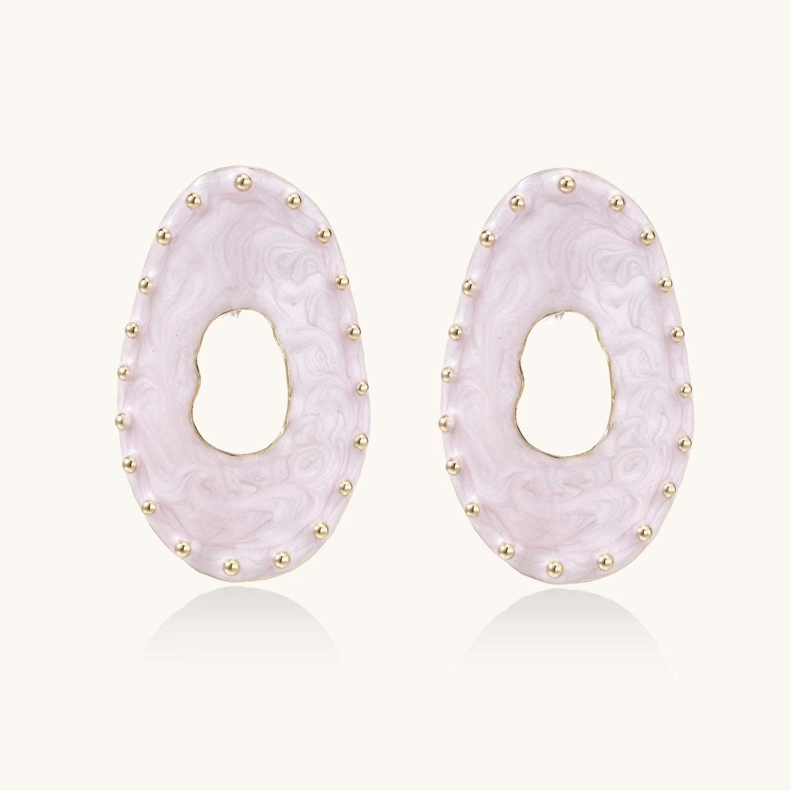 Oval lavender enamel earrings with marbled finish and gold-plated beaded border on cream background.