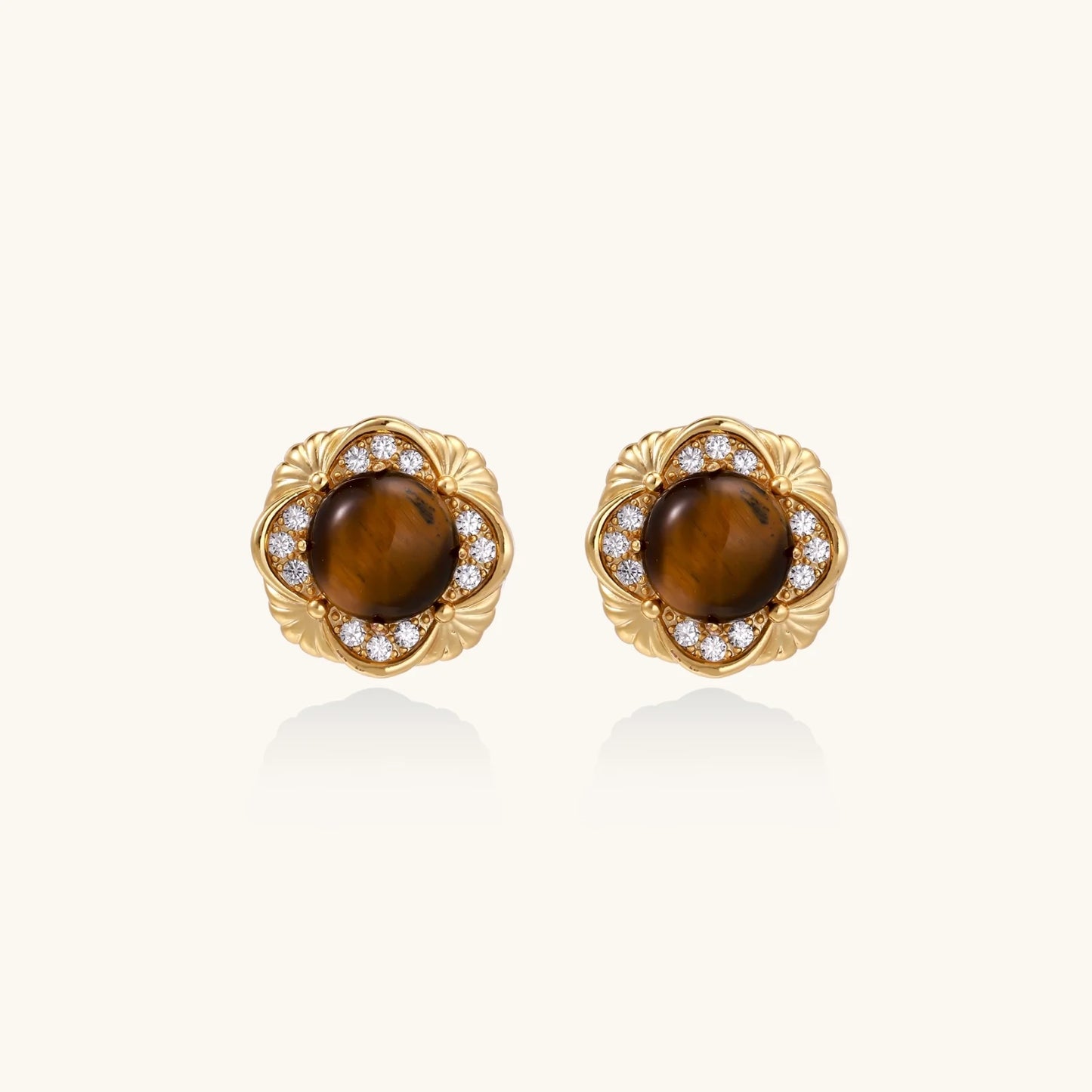 Gold-plated stud earrings with ornate floral frames surrounding cabochon tiger's eye stones and zirconia accents