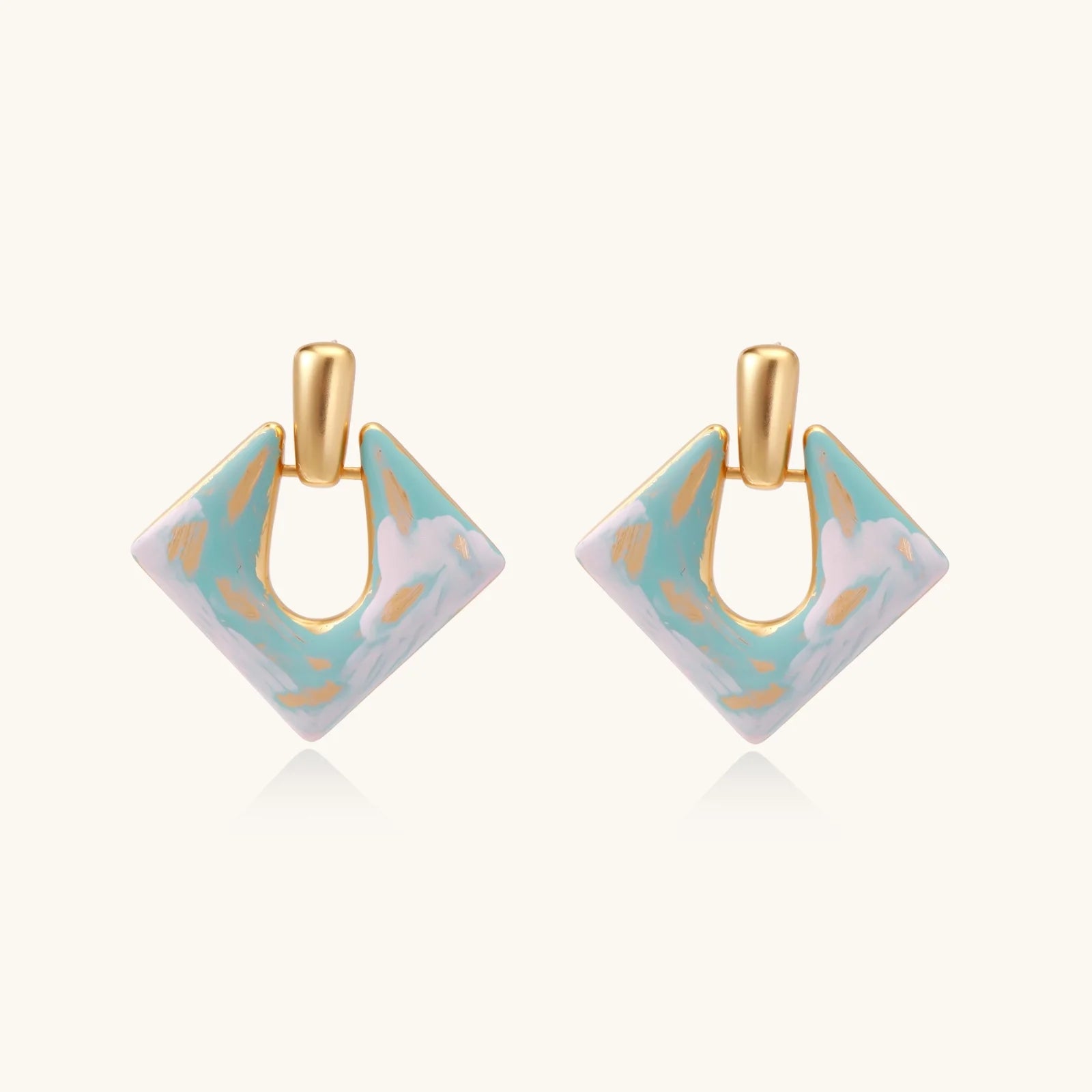 Geometric square enamel earrings with marbled turquoise and lavender pattern, gold U-shaped connector on cream background.