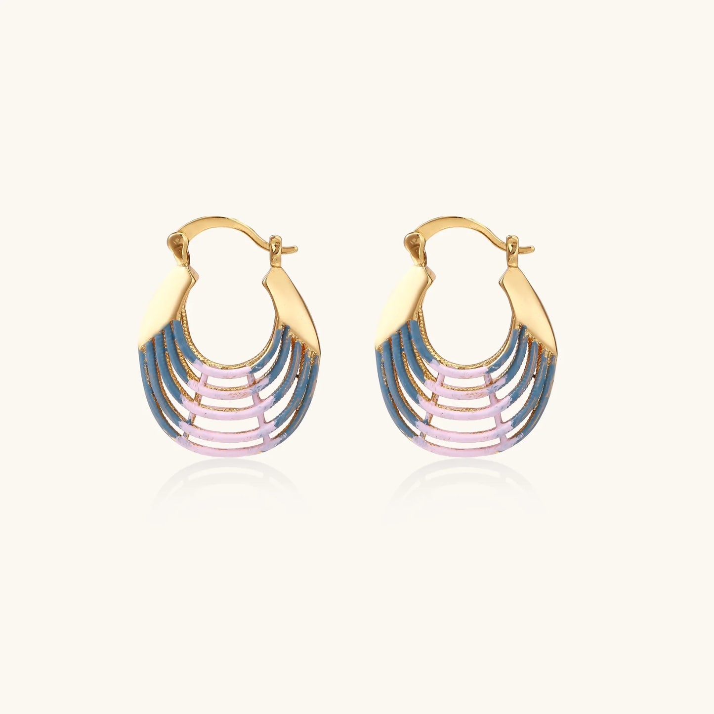 Gold hoop earrings with gradient blue-to-pink enamel in ribbed fan design on beige background