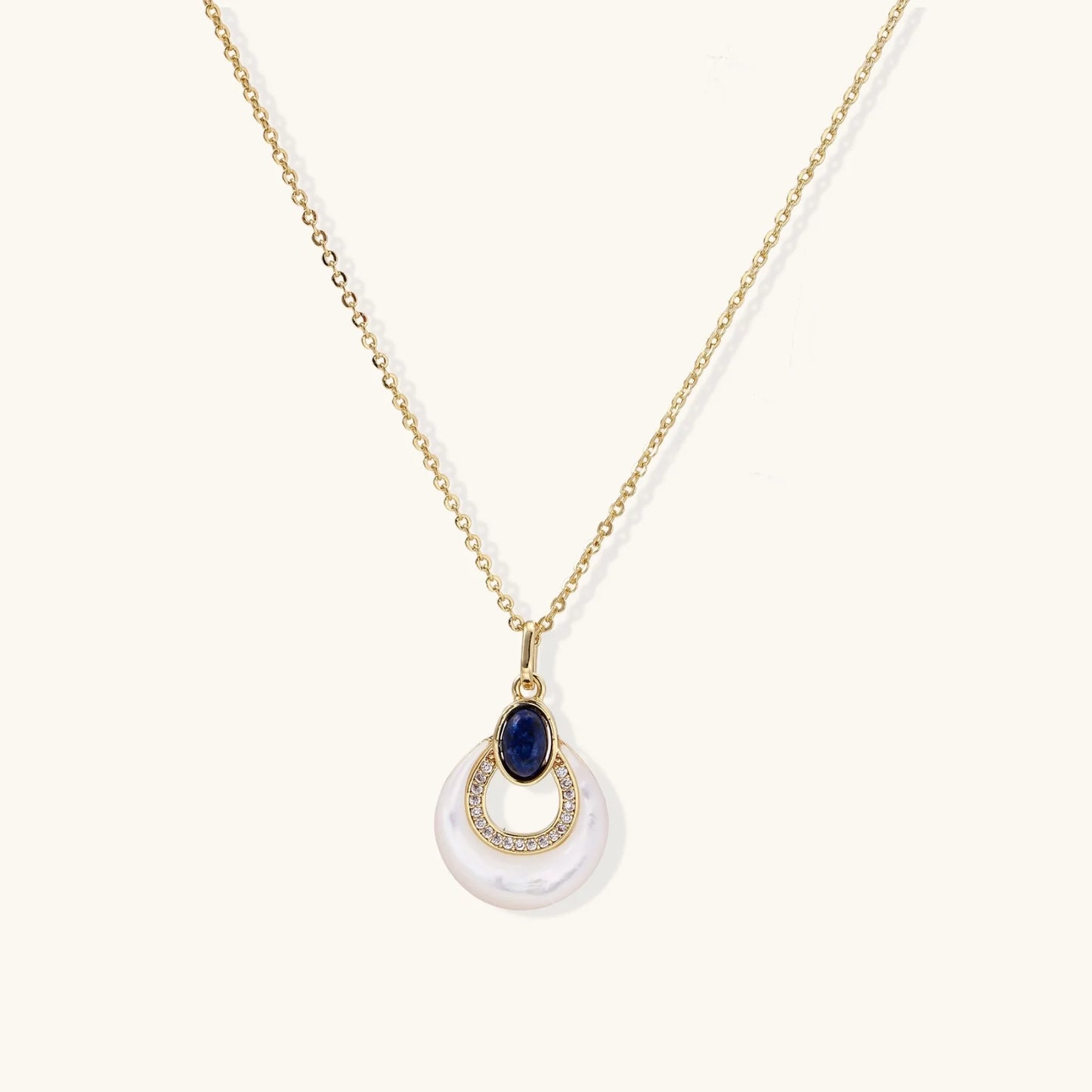 Gold necklace with navy lapis lazuli stone and iridescent mother-of-pearl teardrop pendant with crystal accents