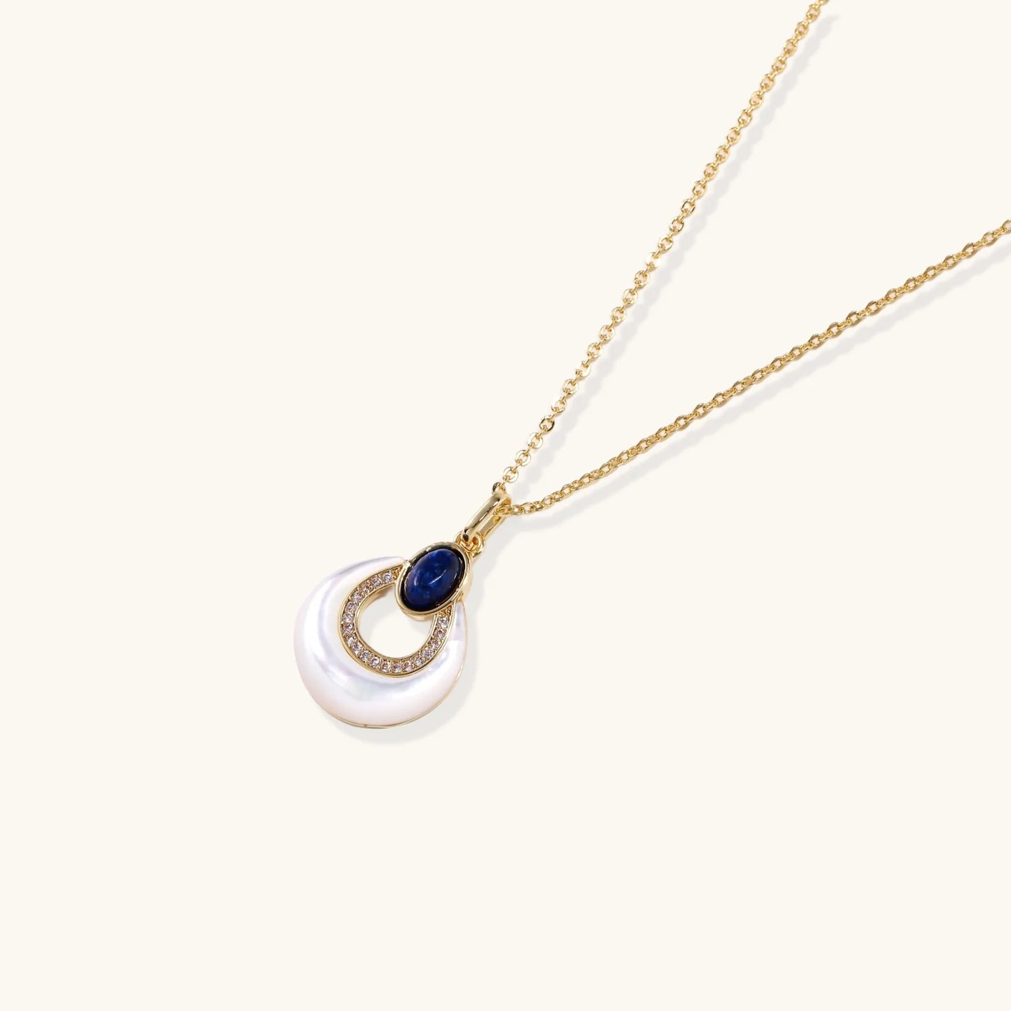 Gold necklace with navy lapis lazuli stone and iridescent mother-of-pearl teardrop pendant with crystal accents