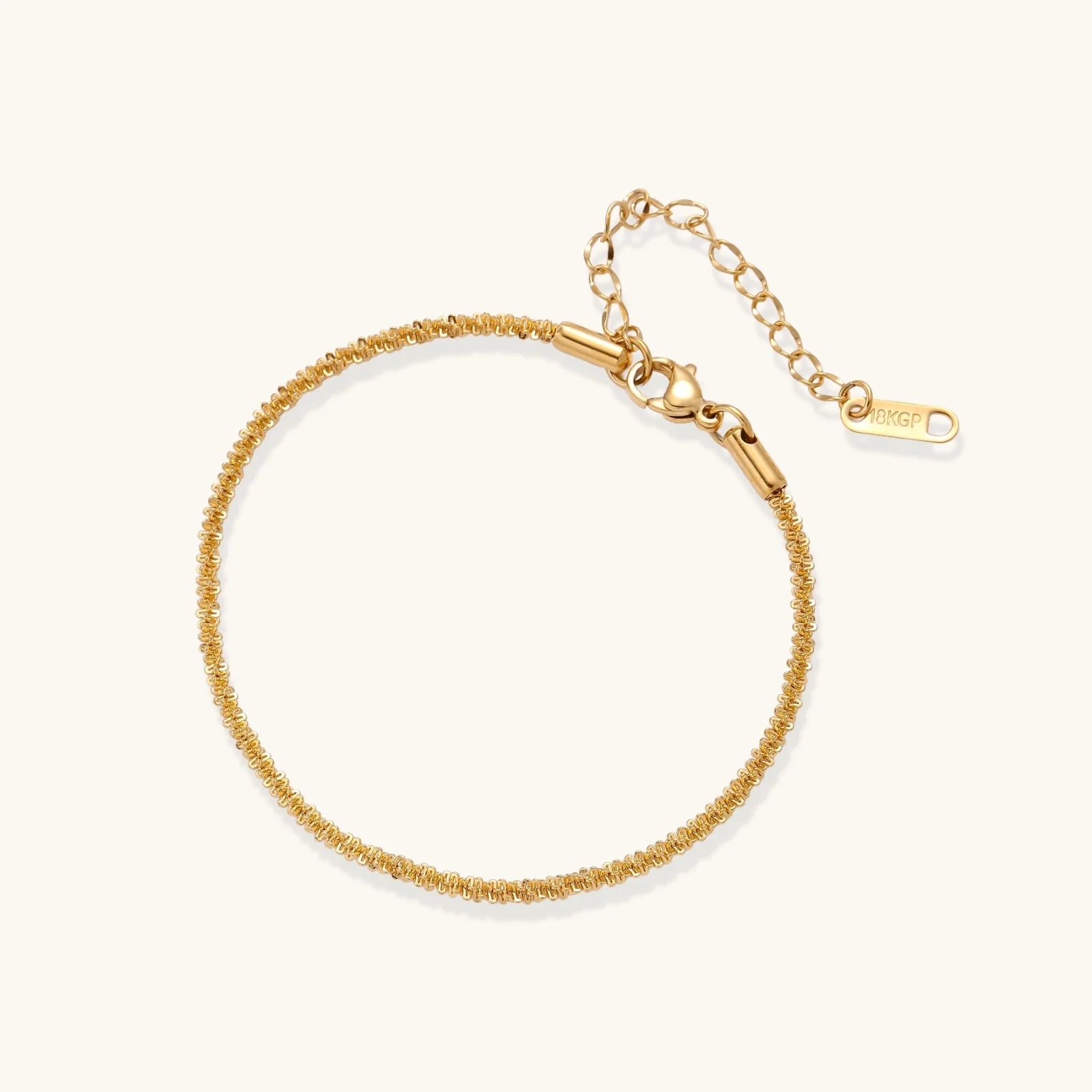 Delicate 18K gold-plated stainless steel bracelet with textured beaded chain on cream background