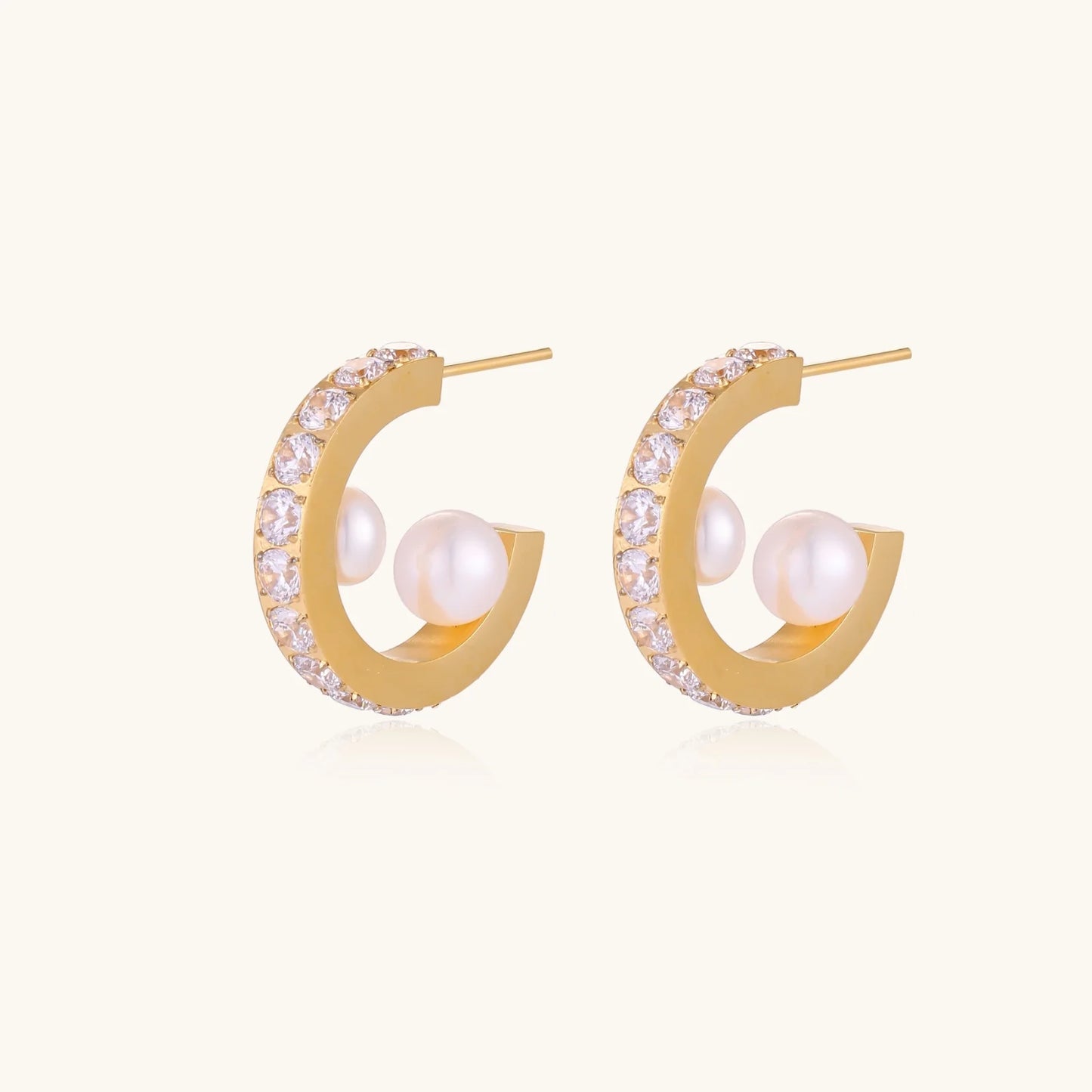 Gold pavé hoop earrings with two freshwater pearls nestled inside the curved design, featuring crystal-studded outer edge.