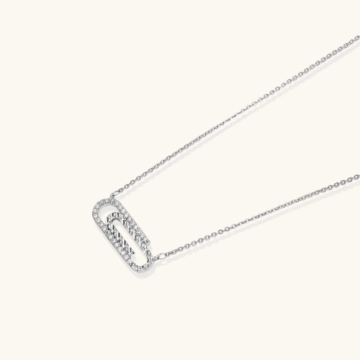 White gold plated necklace with dual-frame geometric pendant featuring crystal pavé border on pale background.