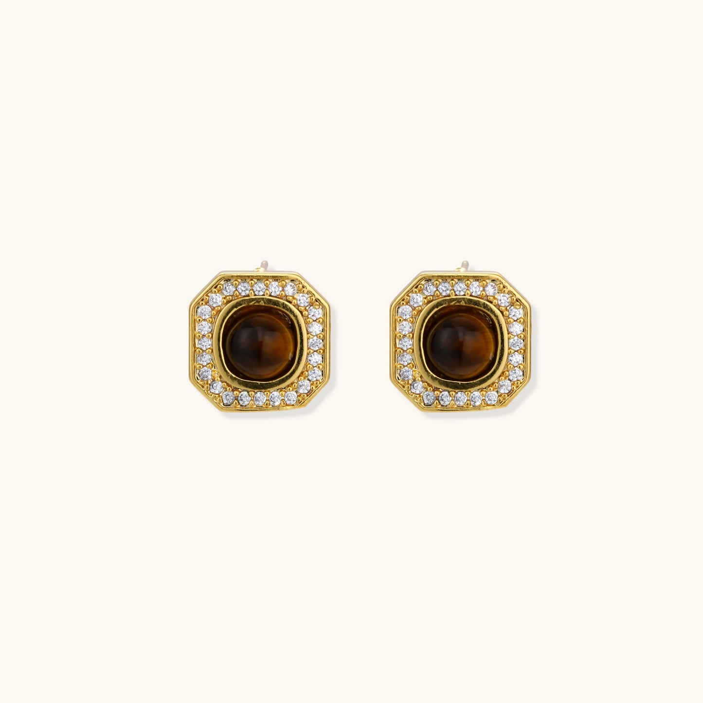 Gold-plated octagonal stud earrings with brown tiger's eye centers and cubic zirconia border on cream background.